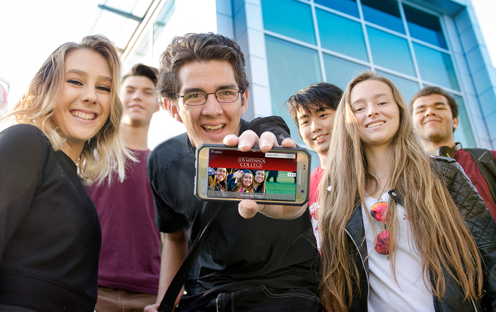 Students showing a responsive website on a phone